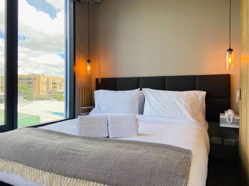 a bedroom with a large bed with a large window at Unique loft con piscina cerca a parque 93 in Bogotá