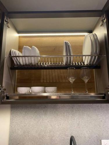 a shelf with plates and wine glasses in a refrigerator at Unique loft con piscina cerca a parque 93 in Bogotá