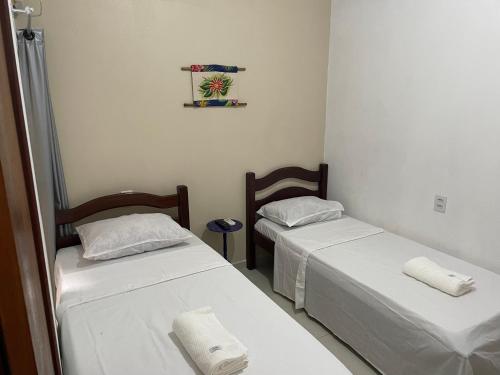 2 posti letto in una piccola stanza con lenzuola bianche di Milagres do Camaragibe a Passo de Camarajibe