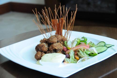 a plate of food with meatballs and vegetables on a table at Addissinia Hotel in Addis Ababa