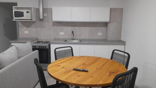 una mesa de madera en una cocina con un bolígrafo en Departamento espectacular vista a la Ciudad en El Challao