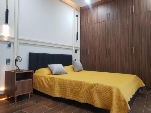 a bedroom with a yellow bed and wooden cabinets at Casa Moreno Deluxe in Ameca