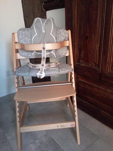 ein Hochstuhl aus Holz mit einem Kissen darauf in der Unterkunft FeWo Am alten Holzplatz in Drübeck