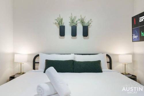 a bedroom with two beds with plants on the wall at Cozy Newly Renovated King Sofa Bed and Smart TV in Austin