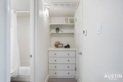 a white closet with a dresser in a room at Cozy Newly Renovated King Sofa Bed and Smart TV in Austin