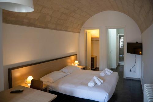 ein Hotelzimmer mit einem Bett und einem Tisch in der Unterkunft Residence Le Vie Del Mosto in Matera