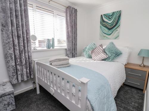 a bedroom with a white bed and a window at 2 Rowan Walk in Hornsea