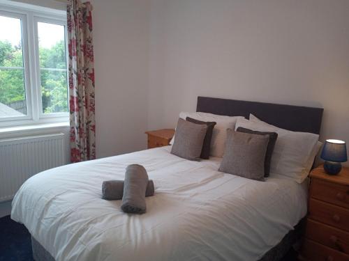 a bedroom with a white bed with two stuffed animals on it at Large 4 Bedroom House in Norfolk Perfect for Families and Groups of Friends in Stoke Ferry