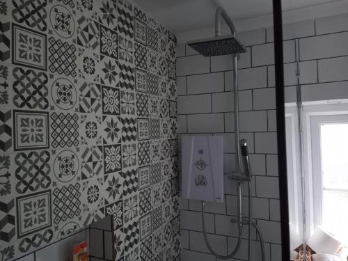 a bathroom with black and white tiles on the wall at Large 4 Bedroom House in Norfolk Perfect for Families and Groups of Friends in Stoke Ferry