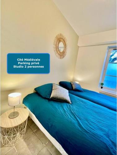 ein Schlafzimmer mit einem blauen Bett und einem Schild an der Wand in der Unterkunft * Au centre de la ville haute D * ZEN LOC 5 in Provins