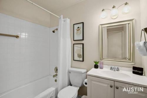 a white bathroom with a toilet and a sink at Relax in Hyde Park Parking Great Location and Tub in Austin