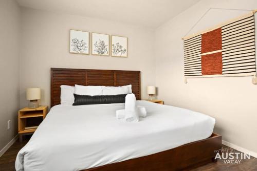 a bedroom with a large white bed with towels on it at Minutes to Zilker, Barton Springs and Free Parking in Austin
