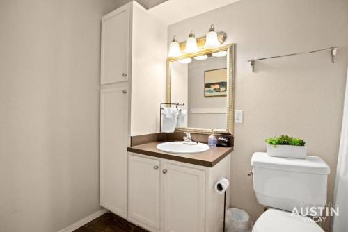 bagno con servizi igienici, lavandino e specchio di Minutes to Zilker, Barton Springs and Free Parking ad Austin
