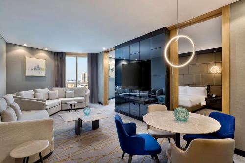 a living room with a couch and a table and chairs at Holiday Inn & Suites - Al Khobar by IHG in Al Khobar