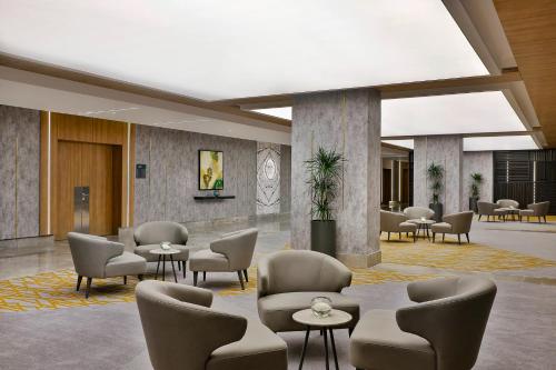a lobby with chairs and tables in a building at Holiday Inn & Suites - Al Khobar by IHG in Al Khobar