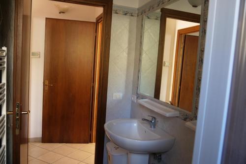 een badkamer met een wastafel, een spiegel en een toilet bij Casa vacanza Riparbella in Riparbella