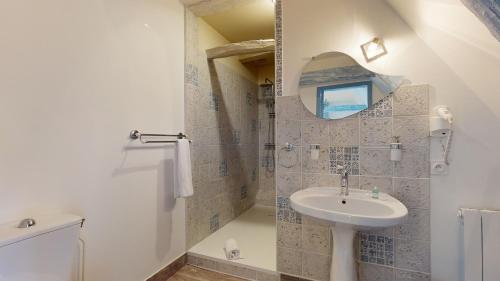 a bathroom with a sink and a mirror at Demeure du Vallon - Chambres d'Hôtes de Charme in Azerat