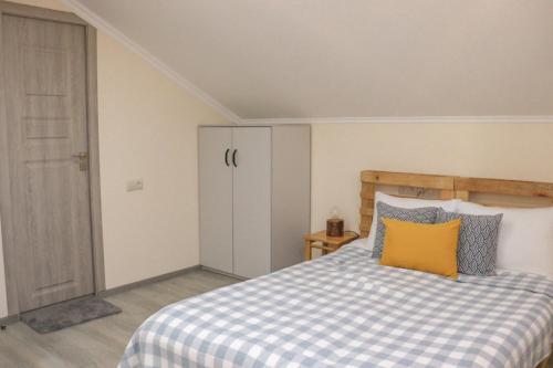 a bedroom with a bed with a yellow pillow on it at Taniq Guesthouse in Artsvaberd