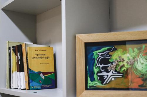 a shelf with books and a picture on it at Taniq Guesthouse in Artsvaberd