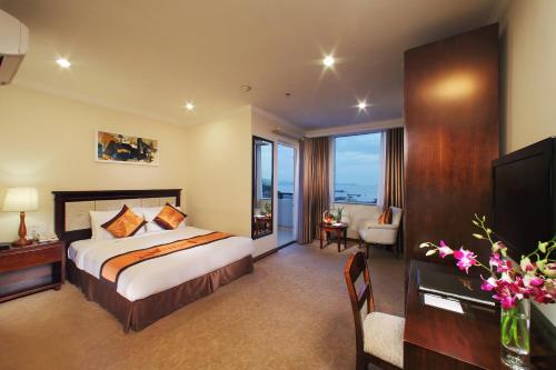 a hotel room with a bed and a desk and a television at Ha Long DC Hotel in Ha Long