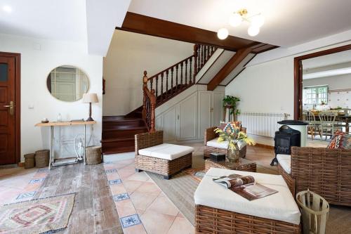 una sala de estar con muebles y una escalera. en Villa Mimosa, 