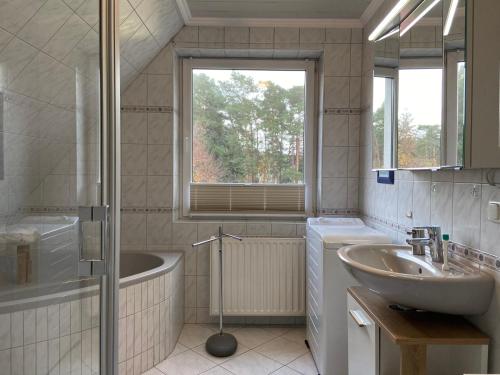 La salle de bains est pourvue d'un lavabo, d'une baignoire et d'une douche. dans l'établissement Kleemann´s Apartment****, à Zossen