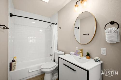 a bathroom with a toilet and a sink and a mirror at Walk to Restaurants or Cook in Subway Tile Kitchen in Austin