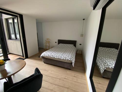 a bedroom with two beds and a table and a chair at Apartment Nevena 3 in Belgrade