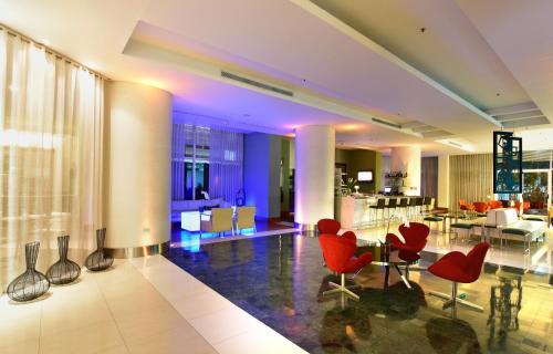 a lobby with red chairs and a dining room at Pestana Caracas Premium City & Conference Hotel in Caracas