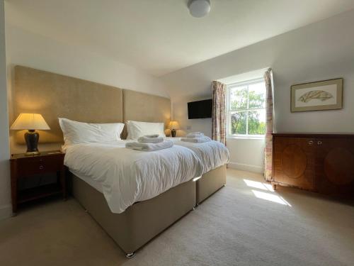 a bedroom with a large bed and a window at Balloan House in Dornoch