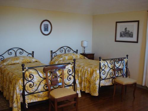 a bedroom with two beds and two chairs at Santuario di Oropa in Biella
