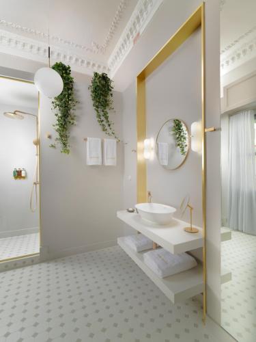 a bathroom with a white sink and a mirror at Monument Hotel in Athens