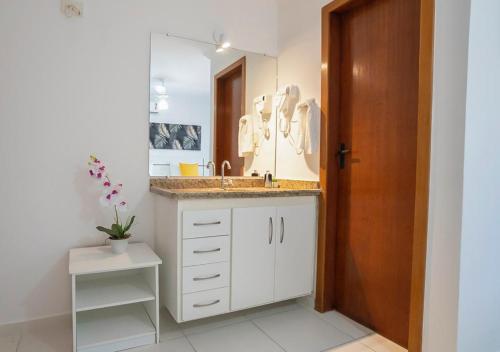a bathroom with a sink and a mirror at DUPLEX 2 SUÍTES MONT SIÃO in Porto Seguro