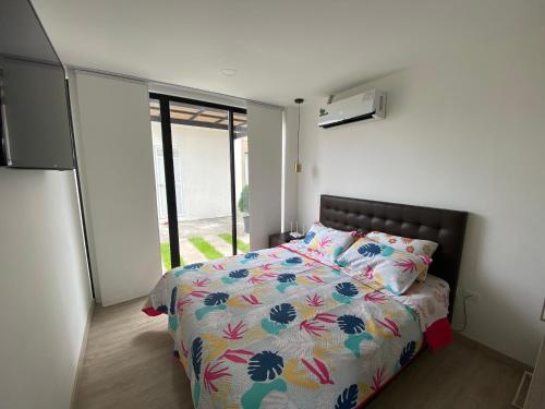 een slaapkamer met een bed met een kleurrijk dekbed bij Suite Nueva en Salinas - Chipipe, en conjunto privado in Salinas