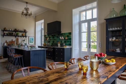 une grande cuisine avec une table et des chaises en bois dans l'établissement Stunning refurbished Chateau in South West France, à Ornézan