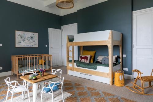 ein Kinderzimmer mit einem Etagenbett und einem Tisch in der Unterkunft Stunning refurbished Chateau in South West France in Ornézan