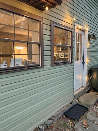 a house with a door and windows on it at Peaceful Seasonal Wooded Cottage close to everything in Tafton