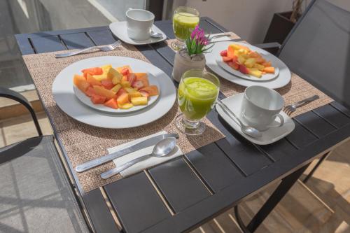 a table with plates of fruit and drinks on it at The Gallery in Mexico City