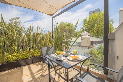a table and chairs on a balcony with a view at The Gallery in Mexico City