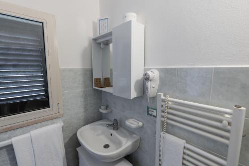 baño con lavabo y aseo y ventana en Agriturismo La Siesta, en Marsiliana