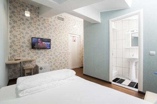 a bedroom with a bed and a tv on the wall at Hotel La Gil in Bucharest