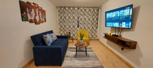 a living room with a blue couch and a tv at Warmisitay HOME in Lima