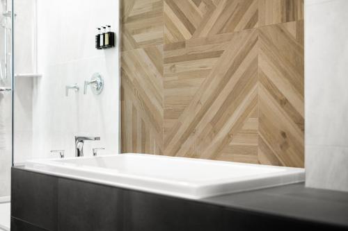 a bathroom with a white sink and a wooden wall at Running Aces Hotel & Casino, Trademark Collection by Wyndham in Forest Lake