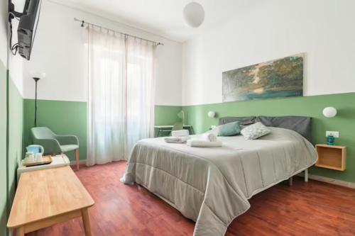 una camera da letto verde e bianca con un letto e un tavolo di Dante Suites a Palermo