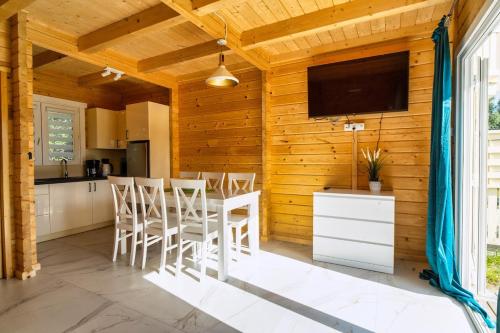 a kitchen with a table and chairs and a television at Perłowe Wzgórze in Ustronie Morskie