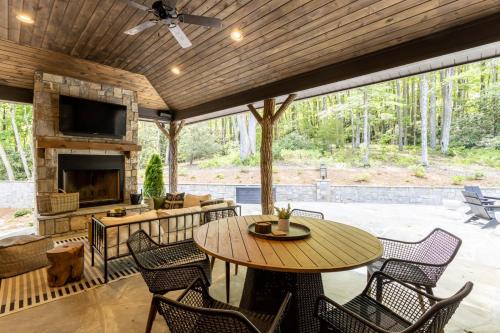 a patio with a table and chairs and a fireplace at Trouvaille in Blowing Rock