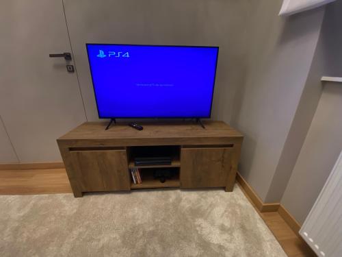 a flat screen tv sitting on a wooden entertainment center at TALIA Apartament Tatarska 4 in Przemyśl