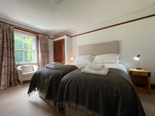 a bedroom with a bed with two towels on it at Balloan Cottage in Dornoch