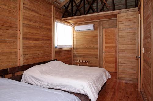a bedroom with two beds in a wooden cabin at Aldea Suncunu playa y alberca privada en Tuxpan in Tuxpan de Rodríguez Cano