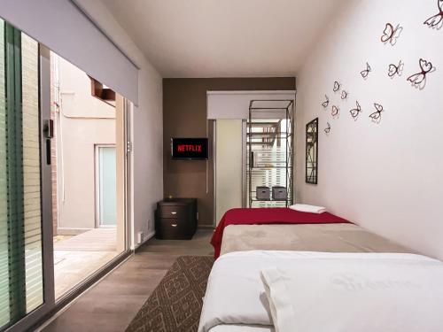 1 dormitorio con 2 camas y reloj en la pared en Puerta Condesa, Rooms & Studios, en Ciudad de México